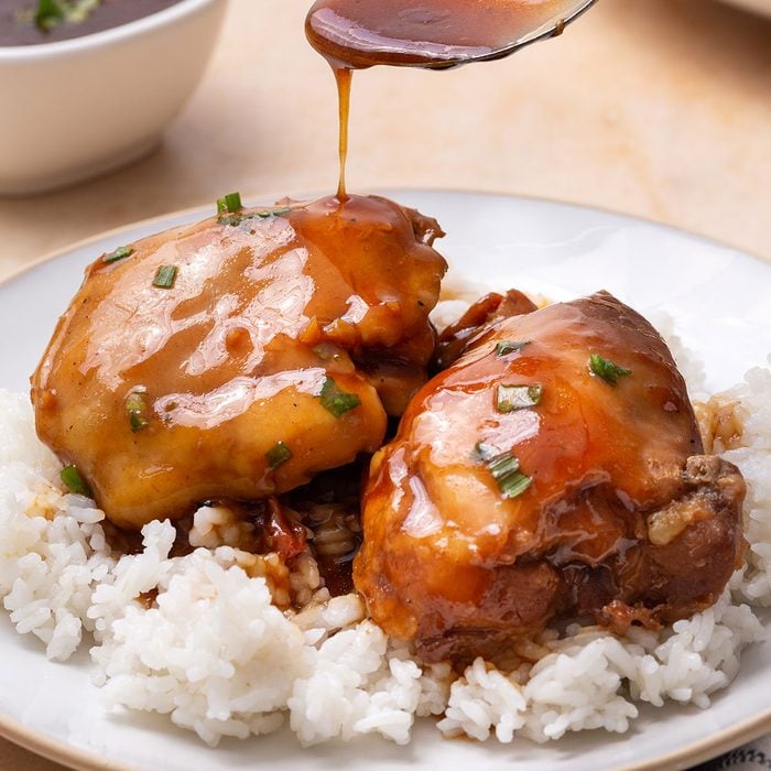 Teriyaki Chicken Thighs on a serving platter garnished with green onion for Taste of Home