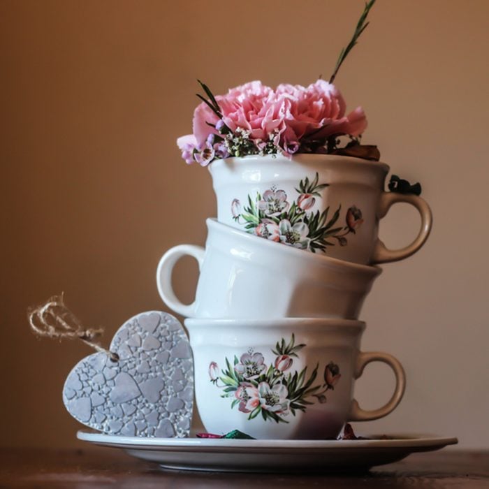 Three teacups stacked on top of one another with floral patterns and designs on them.